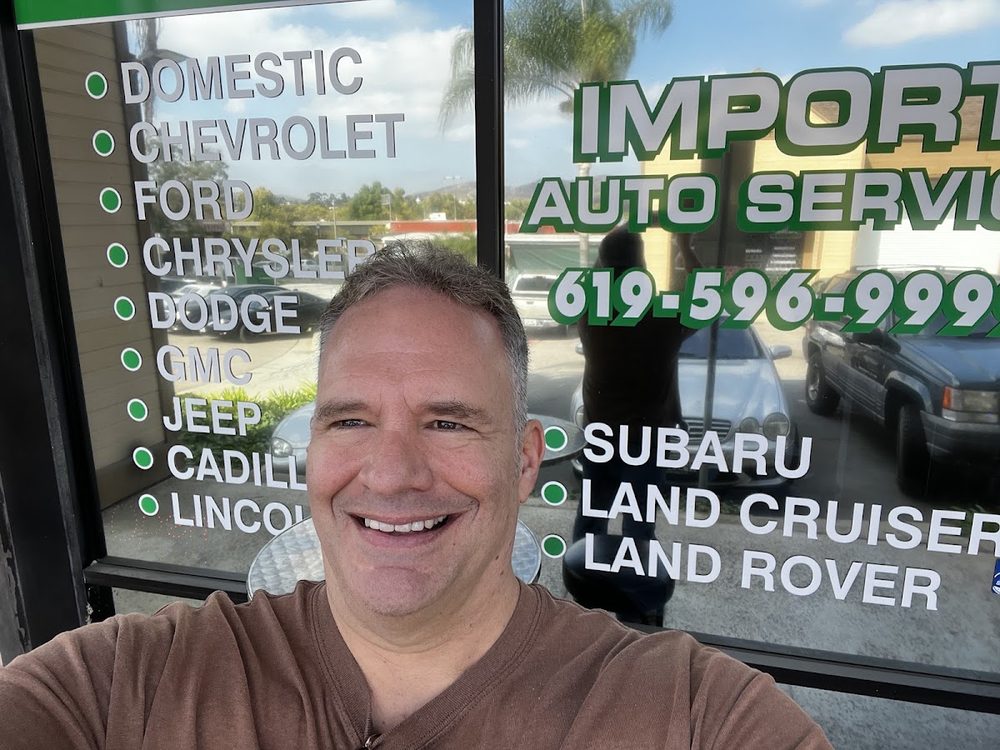 The owner in front of the Import Auto Service window